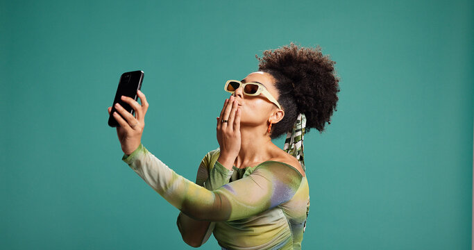 Selfie, kiss or woman in studio with fashion, photograph or trendy clothes on green background. African model, flirt or influencer with space for social media post, profile picture or vlogging update
