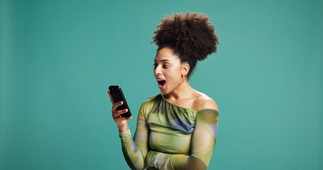 Surprise, smartphone and woman in studio, wow and announcement on green background. Person, mobile...