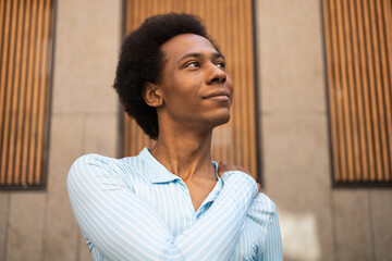 Confident person outdoors against modern wood paneling