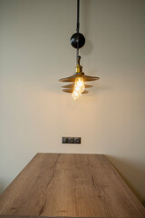 A row of three stylish lamps, vintage style, above a wooden countertop in a kitchen or living room