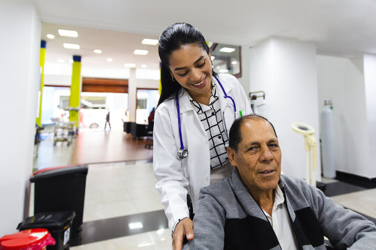 Doctor assisting elderly man in hospital setting