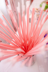 Pink drinking straws in metal container creating a burst of color