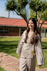 Fototapeta premium Elegant businesswoman walking in a garden, enjoying a sunny day