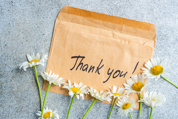 Thank you card with daisies on concrete background