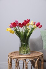 Bouquet of beautiful tulips on rattan table indoors
