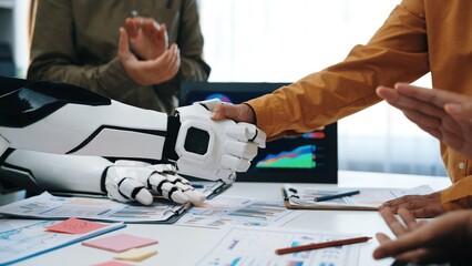 This image captures a moment of collaboration between human and robot in a business environment,...