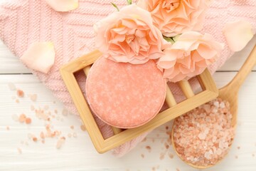 Soap bar, sea salt and beautiful flowers on white wooden table, flat lay