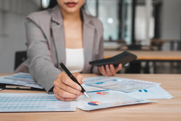 Businesswoman checking documents on stacked desk