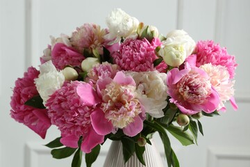 Bouquet of beautiful peonies in vase indoors, closeup
