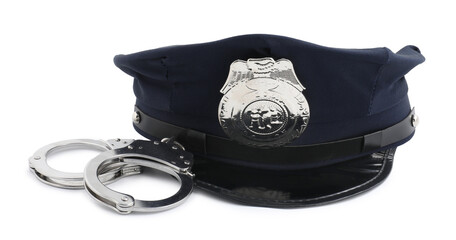Police cap and handcuffs on white background