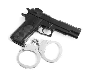 Gun and handcuffs on white background, top view. Police equipment