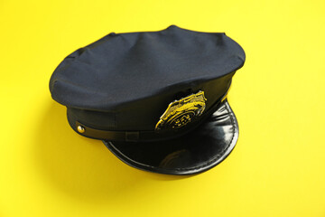 Police cap on yellow background, above view