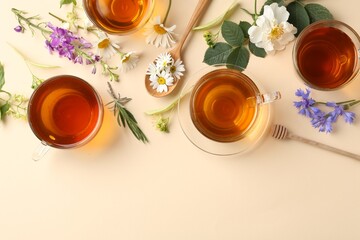 Aromatic herbal tea in glass cups and different flowers on beige background, flat lay. Space for text