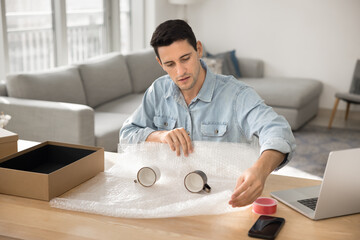 Shipping online order with care. Confident millennial male ecommerce dropshipping store owner...