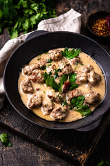 Meatballs in sour cream sauce in a frying pan