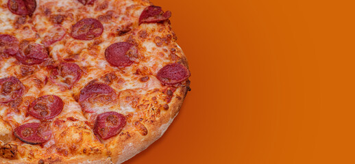 Delicious pepperoni pizza on orange background. Close-up image of a freshly baked pizza. Perfect...