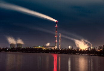 Industrial Smokestack Emissions and Reflections Across a Quiet River at Night
