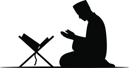 A silhouette of a man kneeling in prayer with a book stand against a white background in a studio shot