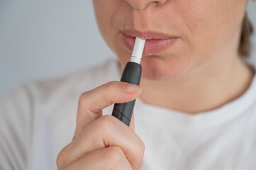 Woman smoking tobacco heating system. Electronic cigarette.