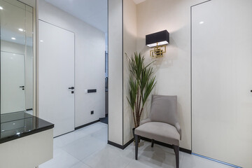 A modern entryway showcases a minimalist design with sleek white walls and a stylish black accent....