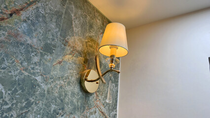 Elegant Wall Sconce Lamp with White Lampshade and Crystal Drop on Luxury Green Marble Wall in Modern Interior