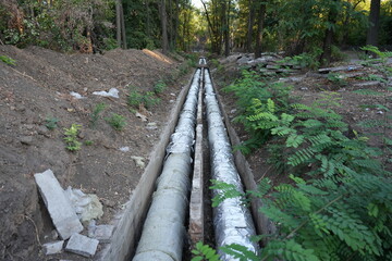 Outdoor view of thermal insulated pipelines in a trench, part of urban heating infrastructure....