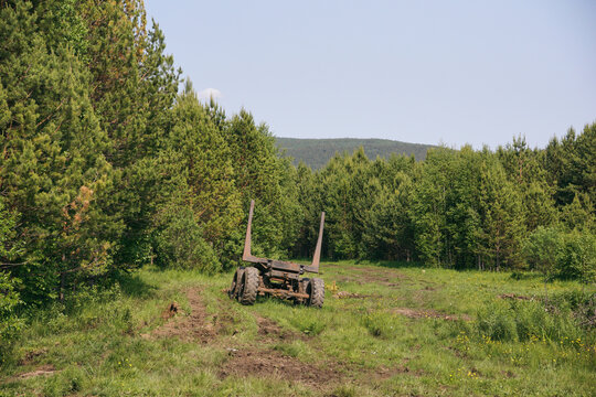 an old broken tractor in the field . Part of a tractor with wheels