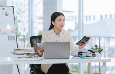 Asian Woman Analyzing Financial Data at Desk
