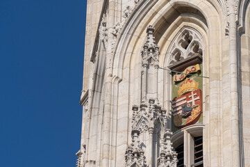Gothic church facade with Hungarian historical coat of arms and arched windows in Budapest