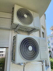 Two outdoor Inverter AC units mounted on a building facade. Modern air cooling system for residential comfort during hot summer days.