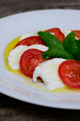 Insalata Caprese Salad with Mozzarella di Bufala Campana, Red Tomatoes and Green Basil Leaves dressed with Extra Virgin Olive Oil