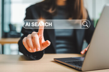 A person touches a digital search bar, labeled "AI SEARCH," illuminating the text. This modern scene, with a laptop in view, highlights technology and artificial intelligence exploration.