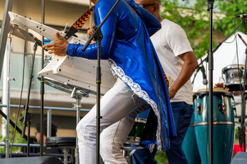 Band playing drums and keytar on a summer music festival on the city