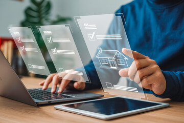A person interacts with digital home icons and checklists on a transparent screen using a laptop and tablet. This scene represents modern real estate technology and workflow efficiency.