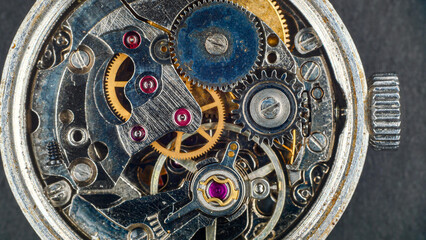 Close-up of the mechanism of an old wristwatch, symbolizing time and its transience, dirty metal and dust