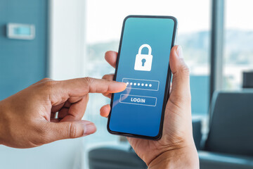 A person interacts with a smartphone displaying a login screen, emphasizing security with a lock icon. The image highlights digital security and authentication in a modern setting.