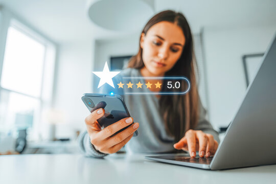 Woman using phone and laptop in modern office, indicating high satisfaction. A floating five-star rating with a score of 5.0 appears, highlighting exceptional service or product reviews.