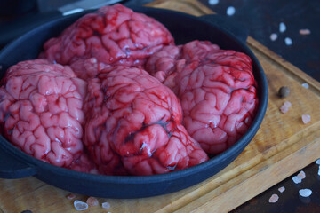 Beef brain on rustic wooden surface with high focus on natural folds and structure. Ideal for...