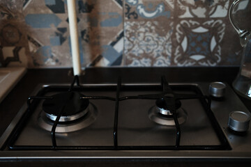 Close-up of a clean modern gas stove with two burners and metallic knobs. Kitchen detail with...