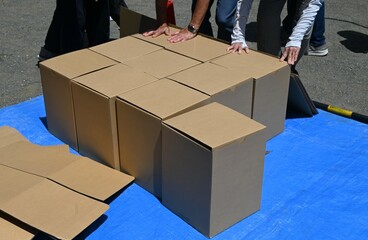 Disaster prevention drill. Assembling a cardboard bed for evacuation shelters. The floor of the...