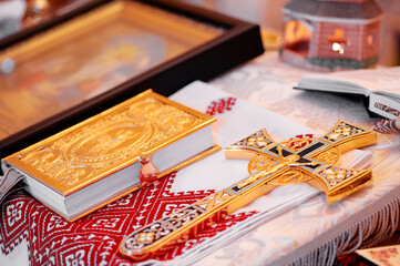 Golden Gospel book and cross on embroidered cloth in Orthodox wedding.