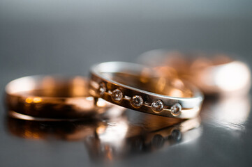 Elegant Gold Wedding Rings With Diamonds on Reflective Surface