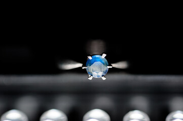 Elegant close-up image capturing a radiant blue gemstone mounted on a sparkling silver ring with a...