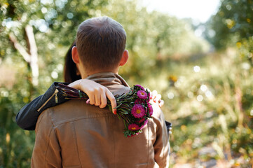 Couple Hugging Outdoors with Flowers in a Romantic Natural Setting