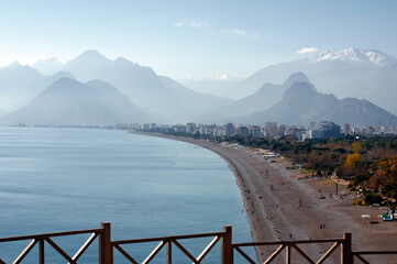 Scenic Coastal Beachfront With Mountains and Urban Views in Sunlight