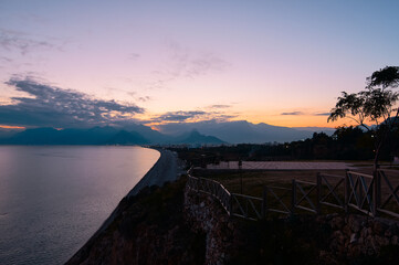 Scenic Coastal View at Sunset with Mountains and Calm Sea