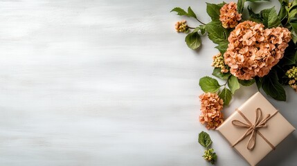 A beautiful arrangement of soft peach hydrangeas and foliage next to a neatly tied gift box, perfect for capturing themes of love, celebration, and gifting moments.