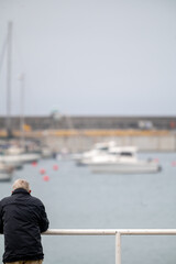 man on the pier looking  at the ships