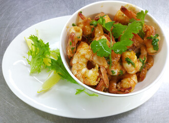 shrimps in tomato sauce with herbs and lemon. tasty and healthy seafood. diet food rich in protein. decorated with sprigs of herbs and lemon wedges