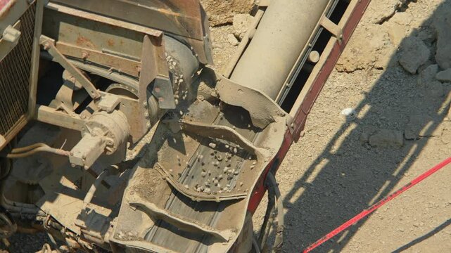 Slow motion of stone slinger conveyor trucks or gravel and  aggregate conveyor system at construction site. Cement mixer truck moves heavy machinery with rocks piling.
